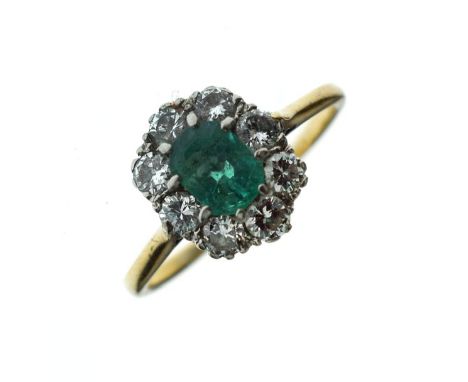 Emerald and diamond cluster ring, unmarked, the step cut emerald, approximately 6.9mm x 5.1mm x 5.2mm deep, enclosed by eight