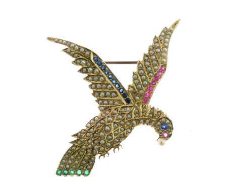 Seed pearl, ruby, sapphire and emerald set parrot in flight brooch, tagged '15ct' with anvil like device and SBA, 5.7cm long,