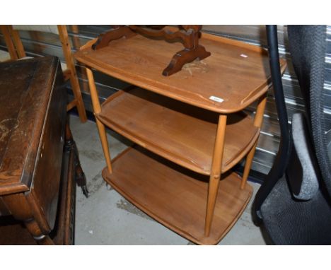 A light stained Ercol tea trolley on shepherds casters, badly marked to top