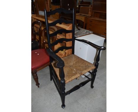 A traditional rush seated ladder back carver chair