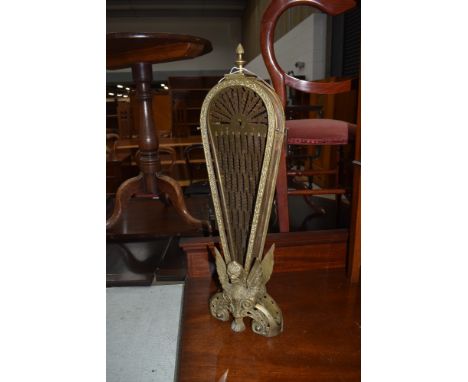 A brass peacock fan style firescreen, having 9 sections