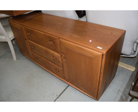 A mid stain Ercol sideboard, having central drawer section flanked by cupboards, width approx. 155cm, on shepherds casters