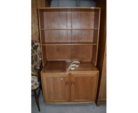 A light Ercol dresser of small proportions having plate rack back over double cupboard, on shepherds casters, approx. Dimensi