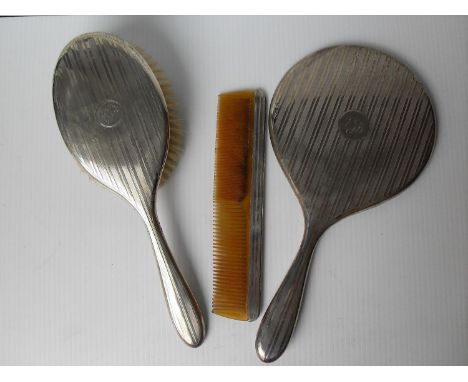 A George V lady's silver three-piece brush set with engine turned design, monogrammed, Birmingham 1921 
