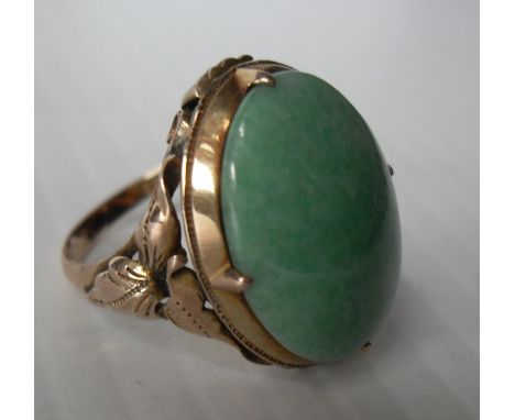 A 14ct yellow gold single stone cabochon jade dress ring, 19 x 13mm approximately in a claw setting, size L, stamped and test