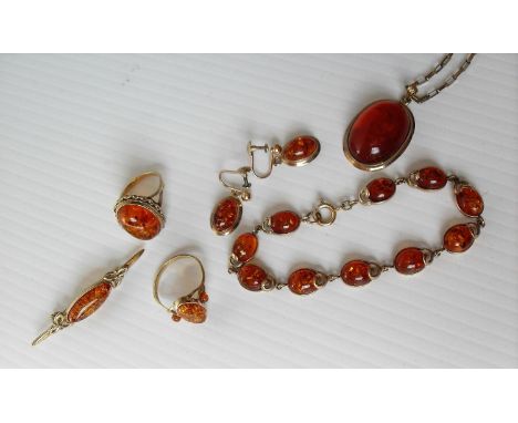 A 9ct yellow gold and amber parure comprising cabochon (25 x 15 x 10mm approximately) pendant with chain, matching earrings a