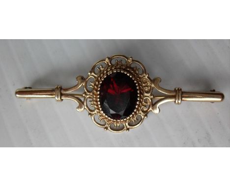 An early 20th century 9ct gold and ruby (9 x 11mm approximately) brooch 5 x 2 cm with filigree claw-setting, hallmarked for B