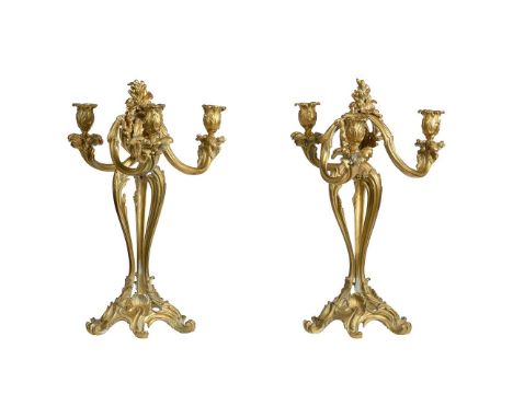 A PAIR OF GILT METAL THREE LIGHT CANDELABRA LATE 19TH OR EARLY 20TH CENTURYOf open scrolled decorationEach 47cm highProvenanc