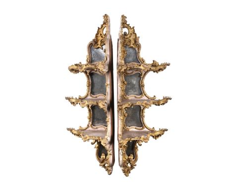 A PAIR OF GILTWOOD AND COMPOSITION CORNER WALL SHELVES IN ROCOCO STYLE19TH CENTURYEach with three tiers and mirrored backs126