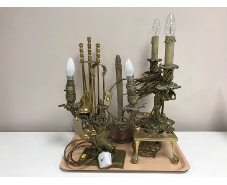 A 19th century two-branch candelabrum converted to a table light, together with a similar lamp,  a brass trivet, fire compani