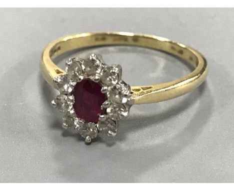 An 18ct gold ruby and diamond cluster ring, size N/O.