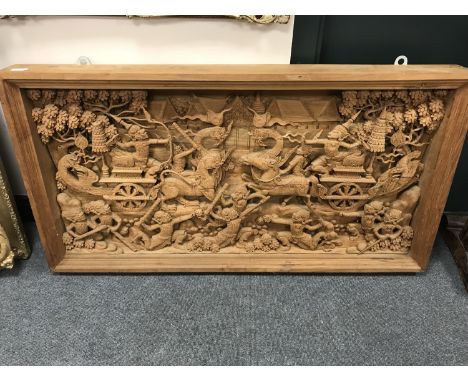 An early 20th century carved Eastern panel, profusely carved with figures in battle, 118 cm x  61 cm. 