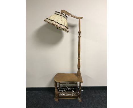 A continental oak multi function standard lamp with magazine rack below, height 160 cm  