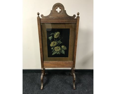 An early 20th century oak fire screen with floral panel, width 60 cm 