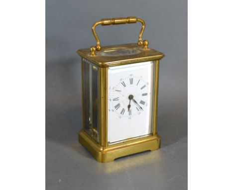 A Brass Cased Carriage Clock with lever escapement, carrying handle and enamel dial with Roman and Arabic numerals 