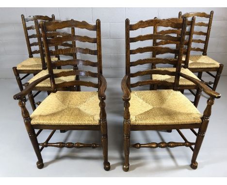 Set of six oak ladder back chairs with rush seats and turned stretchers, two carvers