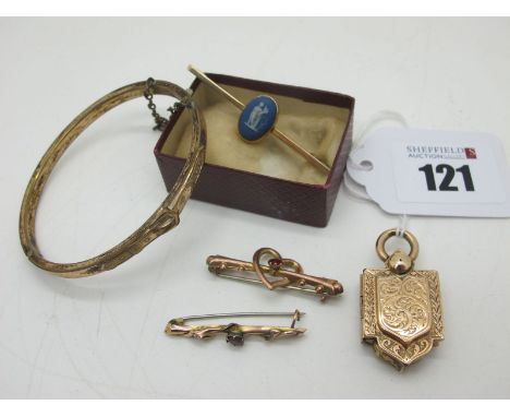 A Decorative Shaped Locket, leaf scroll engraved; together with a hinged bangle, detailed with a belt / buckle to the front, 
