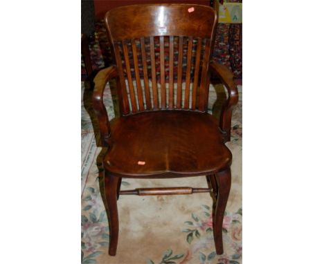 An early 20th century walnut stickback panel seat open elbow chair