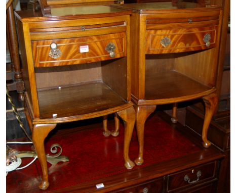 A pair of reproduction mahogany bowfront single drawer bedside tables, each having open compartments and upper brushing slide