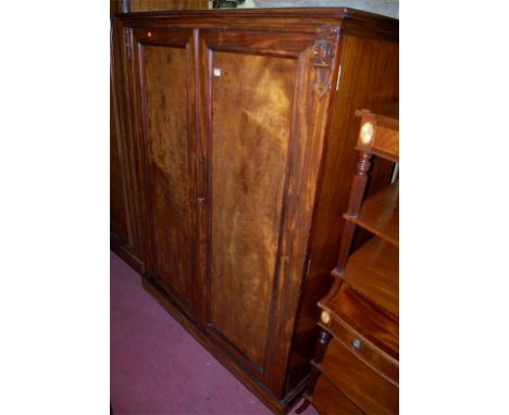 An early Victorian mahogany double door recessed panel wardrobe, having part fitted interior