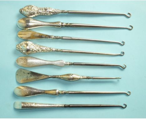 A silver-handled combination button hook/shoe horn, Birmingham 1909, another with engine-turned handle, London 1923 and six o