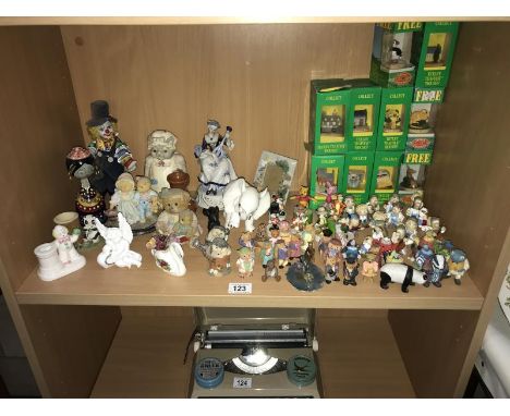 A shelf of miscellaneous. items including. Tetley tea folk and teapots