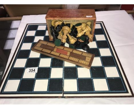 A chess board, chess pieces and a cribbage board