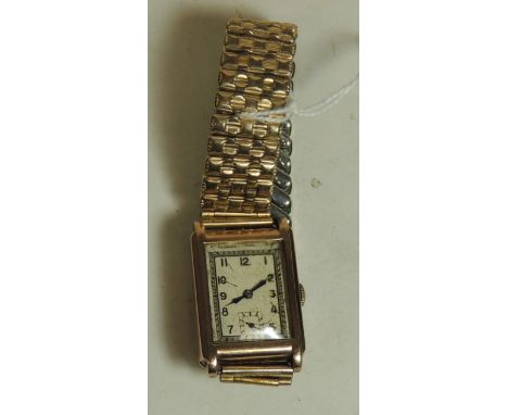 A Gents 9ct gold cased, rectangular cased wristwatch.  Manual wind, silvered dial, arabic numerals and on expanding strap