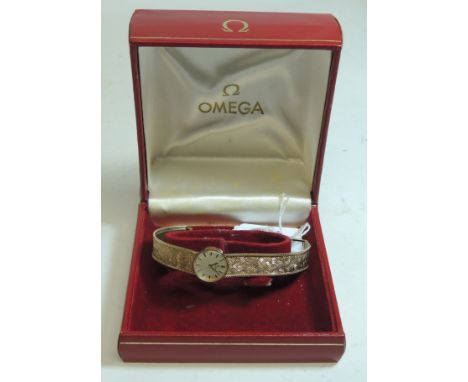 A ladies 9ct gold cased "OMEGA," manual wind wristwatch, on integral 9ct gold mesh strap, silvered dial with gold baton numer