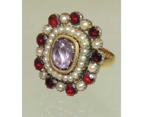 A 19th Century gold metal ring, the band 18ct gold, set with a central amethyst with a surround of split pearls and within a 