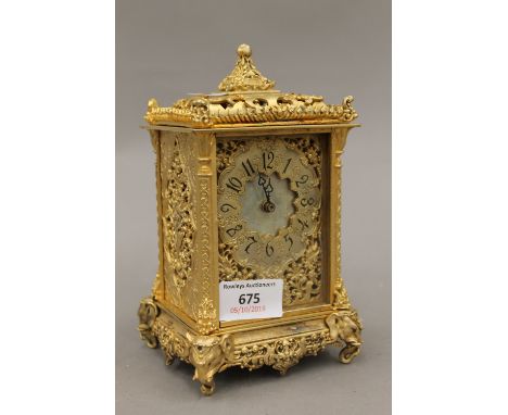 A gilt carriage clock decorated with elephant masks
