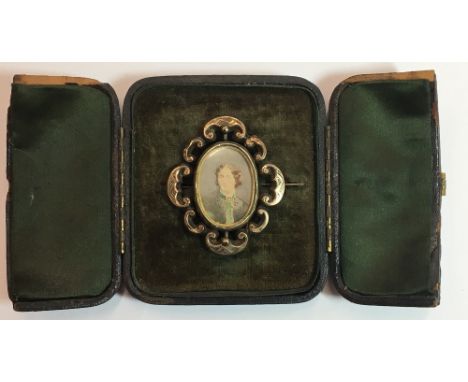 A Victorian yellow metal framed portrait miniature mourning brooch, the portrait opposing a hair worked panel, in original fi