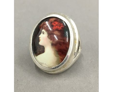 A silver ring depicting a portrait of a girl