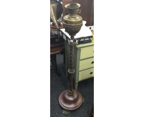 A Victorian brass extending standard lamp, the stem of spiral form, with associated reservoir and shade
