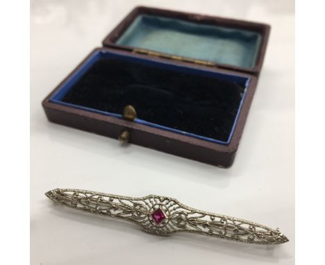 An Art Deco 10 K white gold and ruby bar brooch in fitted box (2.6 grammes total weight)