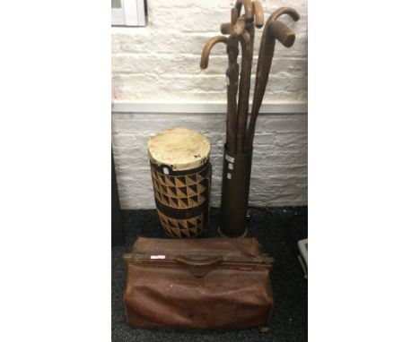 A shell case stick stand, containing sticks, two Gladstone bags and a Tom Tom drum