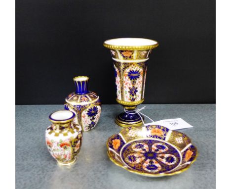 A collection of Royal Crown Derby Imari patterned porcelains to include an urn shaped vase, two miniature vases and a trinket