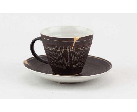 † LUCIE RIE (1902-1995) & HANS COPER (1920-1981); a stoneware cup and saucer partially covered in manganese glaze with sgraff