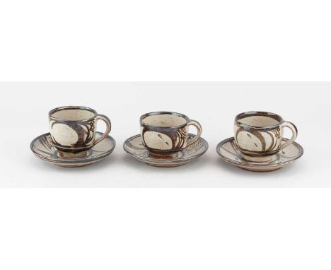 † RUPERT SPIRA (born 1960); a trio of early stoneware cups and saucers covered in pale grey glaze with iron decoration, impre