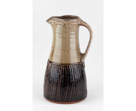 † JIM MALONE (born 1946); a tall part fluted stoneware jug covered in tenmoku breaking to kaki glaze with green ash top, impr