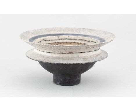 † ROBIN WELCH (1936-2019); a flanged raku bowl covered in white glaze with crackle to the rim and well, made circa 1980, diam