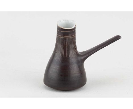 † LUCIE RIE (1902-1995); a stoneware milk jug covered in manganese glaze with sgraffito decoration, impressed LR mark, made c