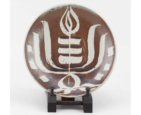 † URSULA MOMMENS (1908-2010); a shallow stoneware dish covered in kaki glaze with wax resist decoration, impressed UD mark, d