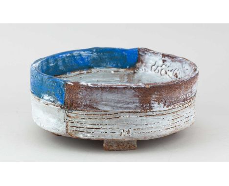 † ROBIN WELCH (1936-2019); a footed stoneware bowl covered in bands of blue, white and rusty glaze with mottled green to half