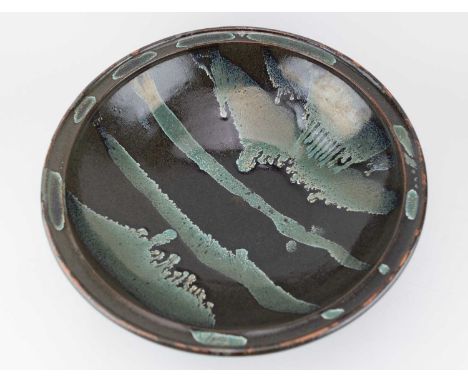 † JIM MALONE (born 1946); a very large stoneware bowl covered in tenmoku breaking to kaki glaze with copper green pours, impr