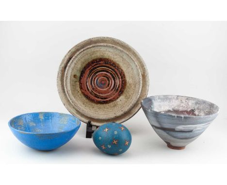 A group of stoneware ceramics by different makers comprising a large plate, conical bowl, another bowl, and an egg form, inci