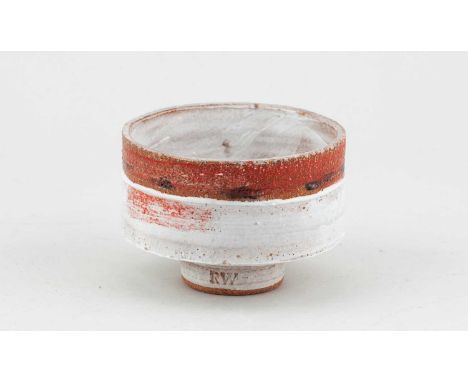 † ROBIN WELCH (1936-2019); a small stoneware bowl covered in bands of white and rusty glaze with black and red enamel decorat