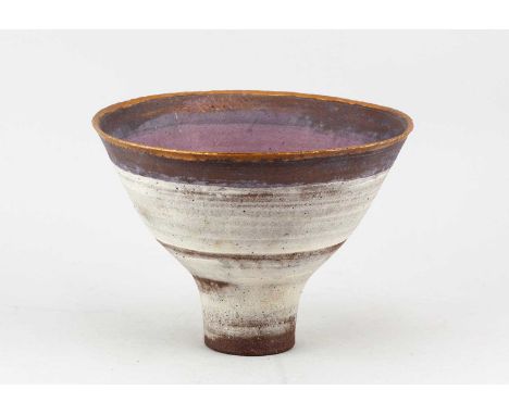 † ROBIN WELCH (1936-2019); a conical stoneware pedestal bowl partially covered in pale grey glaze with lilac band and gold ri