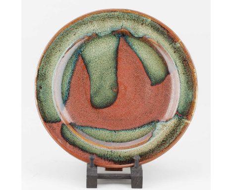 † RAY FINCH (1914-2012) for Winchcombe Pottery; a large stoneware plate with kaki pours, impressed WP. mark, diameter 30cm.Pr