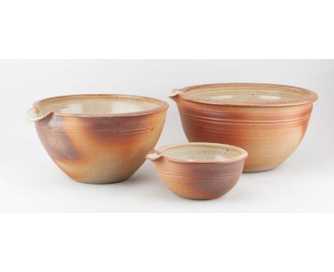 Winchcombe Pottery; a trio of stoneware pouring bowls covered in oatmeal glaze to the interiors, impressed pottery marks, lar